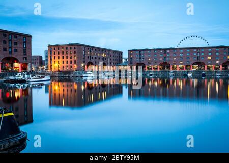 Das Rad von Liverpool hinter dem Albert Dock am Ufer des Flusses Mersey, UNESCO-Weltkulturerbe, in der Abenddämmerung (blaue Stunde) Stockfoto