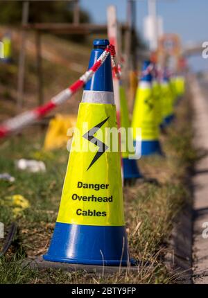 Blaue Kegel warnen vor der Gefahr von Oberleitungskabeln bei Straßenarbeiten auf der Autobahn M1 in England. Stockfoto