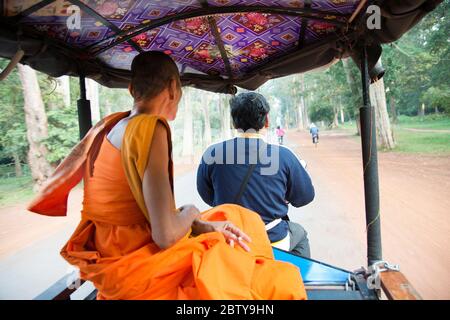 Buddhistischer Mönch, der in einem Tuktuk im archäologischen Park Angkor in Siem Reap, Kambodscha, Indochina, Südostasien, Asien reitet Stockfoto