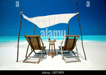 Zwei Liegestühle unter Schutz am Strand, Malediven, Indischer Ozean, Asien Stockfoto