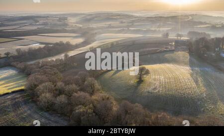 luftaufnahme durch Drohne frostiger, rollender Landschaft bei Sonnenaufgang im Frühling, Devon, England, Vereinigtes Königreich, Europa Stockfoto
