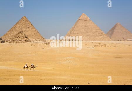 Touristen reiten Kamele, große Pyramiden von Gizeh, UNESCO-Weltkulturerbe, Gizeh, Ägypten, Nordafrika, Afrika Stockfoto