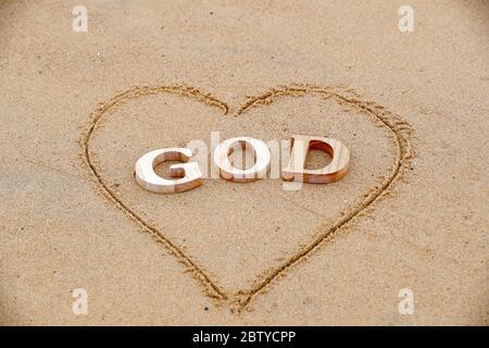 Holzbuchstaben, die das Wort GOTT mit Herz auf einem Hintergrund von Strand Sand, Christian Symbol, Vietnam, Indochina, Südostasien, Asien Stockfoto