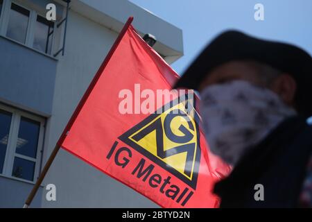 Leipzig, Deutschland. Mai 2020. Ein Demonstrator mit Gesichtsmaske geht neben einer Fahne von IG Metall. Mitarbeiter der Schaudt Mikrosa GmbH demonstrieren im Stadtteil Plagwitz gegen die geplante Schließung ihres Werks mit 165 Arbeitsplätzen. Unterstützt werden sie laut IG Metall von Mitarbeitern verschiedener Leipziger Werke, die in den letzten Jahren von Stilllegungsplänen betroffen waren. Quelle: Sebastian Willnow/dpa-Zentralbild/ZB/dpa/Alamy Live News Stockfoto