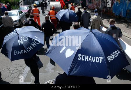 Leipzig, Deutschland. Mai 2020. Mitarbeiter der Schaudt Mikrosa GmbH demonstrieren im Stadtteil Plagwitz gegen die geplante Schließung ihres Werks mit 165 Arbeitsplätzen. Unterstützt werden sie laut IG Metall von Mitarbeitern verschiedener Leipziger Werke, die in den letzten Jahren von Schließungsplänen betroffen waren. Die Demonstranten tragen Regenschirme mit der Aufschrift "NÖ, einfach NÖ!" Oder 'ich liebe Schaudt Mikrosa'. Quelle: Sebastian Willnow/dpa-Zentralbild/ZB/dpa/Alamy Live News Stockfoto