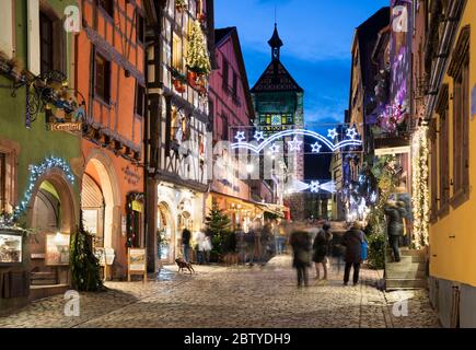 Rue du General de Gaulle bedeckt mit Weihnachtsschmuck beleuchtet bei Nacht, Riquewihr, Elsass, Frankreich, Europa Stockfoto