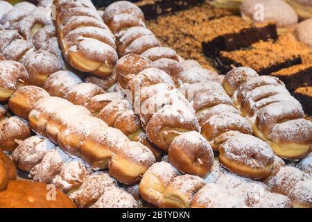 Präsentation traditioneller Donuts im Weihnachtsmarkt in Österreich (Übersetzung: Alter Wiener Apfelstrudel; brezen-Donut mit Zimt Stockfoto