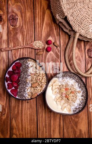 Himbeeren Smoothie Schüssel auf weißem Hintergrund. Draufsicht. Himbeeren und Chia Samen im Smoothie Schalen gekrönt mit gefrorenen Beeren und Müsli. Stockfoto