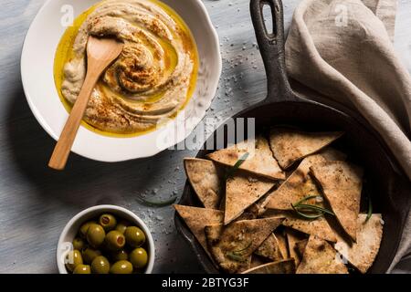 Hausgemachte Humusschale, dekoriert mit d Olivenöl über einem rustikalen Holz klaren Hintergrund. Draufsicht Stockfoto