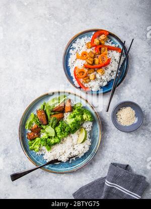 Vegane Teryaki Tempeh oder tempe buddha Schalen mit Reis, gedämpftem Brokkoli, Spinat und Limette auf schwarzem Hintergrund. Gesunde Ernährung Stockfoto