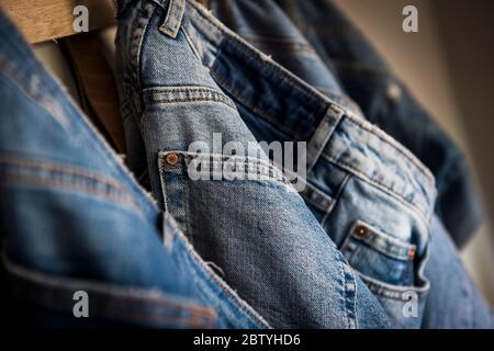 Jeans aus Denim hängen an Holzpflöcken. Stockfoto