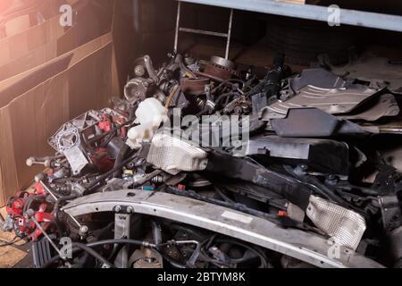 Ein Stapel von Ersatzteilen in einem Autoservice-Lager mit verschiedenen Einheiten von Auto-Eisen-Kunststoff auf dem unteren Regal an einer Auto-Parsing oder Garage. Stockfoto
