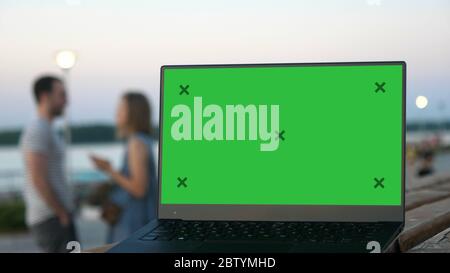 Frau wartet auf ihren Freund. Laptop auf einer Bank mit blanken s Stockfoto