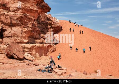 Touristen klettern Sanddüne in Wadi Rum, Aqaba, Jordanien Stockfoto