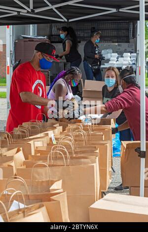 Detroit, Michigan - Freiwillige verpacken während der Coronavirus-Pandemie Lebensmittel für die kostenlose Verteilung in einer Nachbarschaft mit geringem Einkommen. Die Verteilung war o Stockfoto