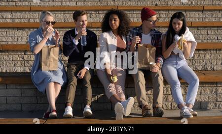 Multikulturelle Gruppe von Freunden essen und diskutieren ihr Studium Stockfoto
