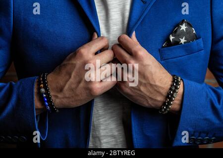 Schmuck Armbänder auf der Hand, aus Natursteinen und Mineralien, handgefertigt. In einem Business-Anzug. Stockfoto