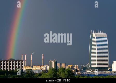 Dramatische, lebendige Stadtansicht von dunklem Himmel und hellem Regenbogen nach Sturm über dem Industriekomplex in der städtischen Umwelt in Sofia Bulgarien, Europa, EU Stockfoto