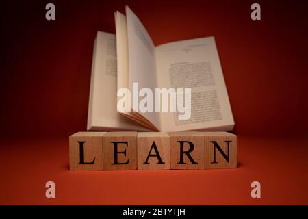 Das Wort lernen von Holzwürfeln. Der Hintergrund wurde in Rot und im Studio aufgenommen. Nahaufnahme. Stockfoto