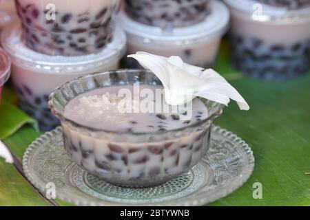 Klebriger Reis und schwarze Bohnen in Kokosmilch, traditionelles thailändisches Dessert. Stockfoto