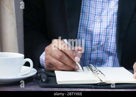 Geschäftsmann Hand Schreiben auf Notizblock, Nahaufnahme Stockfoto