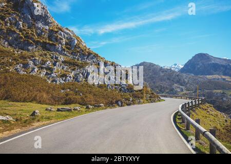 Blick auf die wunderschöne Berglandschaft durch die Windschutzscheibe an einem sonnigen Tag. Ein Auto über die kurvenreiche Straße im Nationalpark Picos de Europa. C Stockfoto