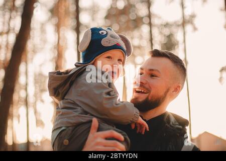 Glücklicher Vater mit verspielten Sohn im Park während sonnigen Tag im Herbst Stockfoto