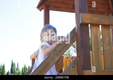 Kleines blauäugiges Mädchen spielt auf dem Spielplatz Stockfoto