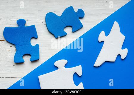 Fragmente des Puzzles auf einem zweifarbigen Hintergrund. Weiße und blaue unmontierte Rätsel über und unter der Diagonallinie. Psychologische Tests. Profes Stockfoto
