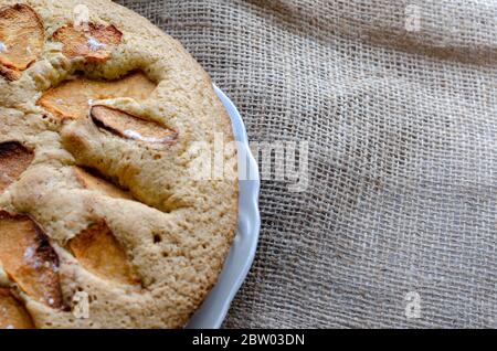 Leckere Torte mit Quitten-Scheiben. Hausgemachte süße Quitten-Pie. Traditionelle runde Torte auf Burlap. Backen mit Scheiben Obst. Ansicht von oben in einem Winkel. Nahaufnahme Stockfoto