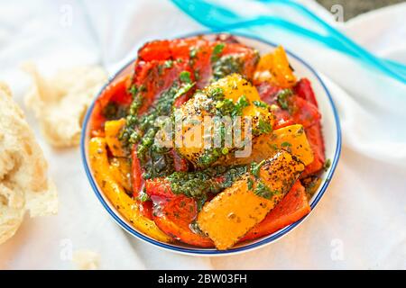Rote und gelbe Paprika mit grünem Pesto und Brot Stockfoto