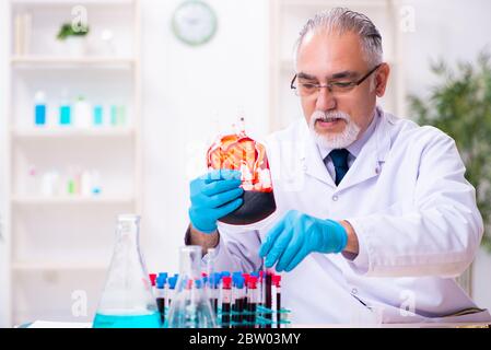 Der alte, im Labor arbeitende Chemiker Stockfoto