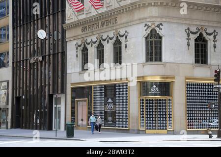 Ein Paar trägt Masken, das während der Sperrung des Coronavirus die leere 5th Avenue herunterläuft, New York City, USA, Mai 2020 Stockfoto