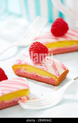 Himbeerscheiben. Drei Scheiben Marmorkuchen und Glasur Stockfoto