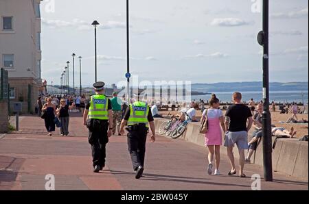 Portobello, Edinburgh, Schottland. 28 Mai 2020. 25 Grad am späten Nachmittag am Meer. Der Strand und die Promenade waren recht voll, die Polizei ging weiter, aber sie kümmerten sich nicht darum, mit jemandem über das Sitzen zu sprechen, da der schottische erste Minister einige der Einschränkungen für die schottische Öffentlichkeit lockert. Stockfoto