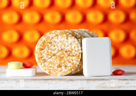 Die Dosis von mehreren verschiedenen Tabletten wird vor dem Hintergrund von Pillen in Blisterpackungen gesehen. Stockfoto