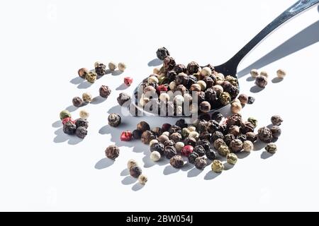Pfeffer mischen in einen metallenen Löffel. Isoliert auf weiß Stockfoto