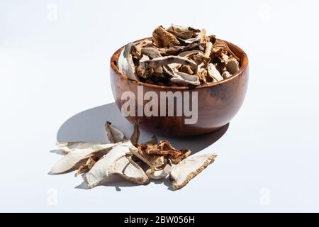 Getrocknete Pilze in einer Holzschale auf weiß isoliert Stockfoto
