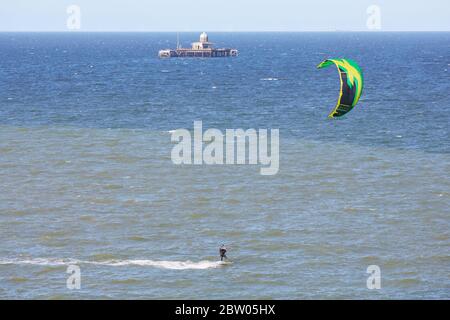 Herne Bay, Kent, Großbritannien. 28. Mai 2020: UK Wetter. Kitesurfer und Windsurfer nutzen die Nordostbrise mit dem verlassenen alten Pier an einem schönen sonnigen Tag, der kühler ist als es gewesen ist. Credit Alan Payton/Alamy Live News Stockfoto