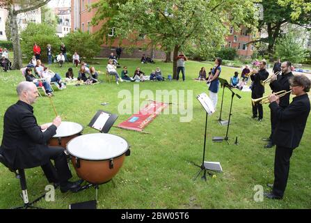 Leipzig, Deutschland. Mai 2020. Drei Trompeter und ein Schlagzeuger des Gewandhausorchesters geben am Nachmittag im Innenhof der Blüthnerstraße in Leipzig ein Konzert für die Bewohner. Der Nachbarschaftshilfverband der Leipziger Wohnungsbaubehörde wird sich mit der Musik bei den Bewohnern für ihre Hilfe während der Corona-Zeit bedanken. Seit Mai geben Musiker des Gewandhausorchesters kleine Konzerte in verschiedenen Besetzung in Pflegeheimen und Innenhöfen der Stadt. Quelle: Waltraud Grubitzsch/dpa-Zentralbild/dpa/Alamy Live News Stockfoto