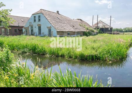 Alte Farm und Heuhaufen in Verfall. Klassische Ansicht der holländischen Landschaft in der Nähe von Gouda, Niederlande. Stockfoto
