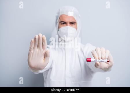 Foto von professionellen Experten Kerl Virologie Zentrum halten Patienten Blutprobe Covid Arm heben weg bleiben gefährlich tragen Maske Kapuze Anzug Kunststoff Gesicht Stockfoto