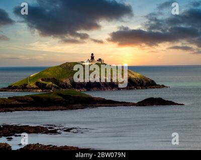 Sonnenuntergang über dem Leuchtturm auf Ballycotton Island. Stockfoto
