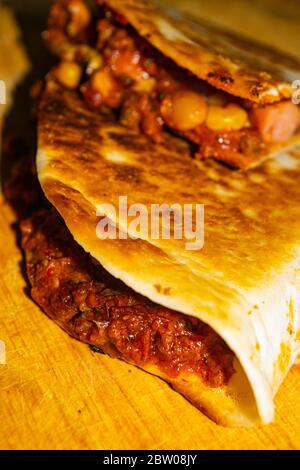 Quesadilla mit Hackfleisch, Wurst, roten Bohnen, Mais, Zwiebeln und Tomatensauce. Ein traditionelles mexikanisches Essen. Nahaufnahme Stockfoto