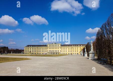 Wien, Österreich - 8. März 2017: Blick auf Schloss Schönbrunn und Menschen, die an einem sonnigen Tag durch den Schönbrunner Garten spazieren Stockfoto