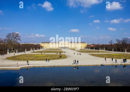 Wien, Österreich - 8. März 2017: Menschen, die durch den Schönbrunner Garten mit Schloss Schönbrunn im Hintergrund laufen Stockfoto