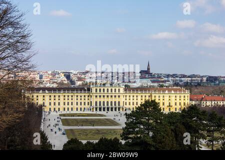 Wien, Österreich - 8. März 2017: Blick auf Menschen, die durch den Schönbrunner Garten mit Schloss Schönbrunn und Wien im Hintergrund laufen Stockfoto