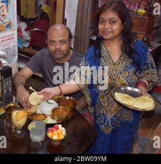 Der indische bengalische Mann isst während seiner Frau während des Jamai Soshti Rituals Essen Stockfoto