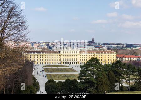 Wien, Österreich - 8. März 2017: Blick auf Menschen, die durch den Schönbrunner Garten mit Schloss Schönbrunn und Wien im Hintergrund laufen Stockfoto