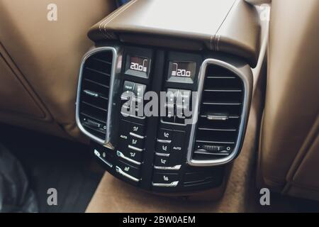 Bedienfeld mit digitalem Mehrfarbendisplay und Knöpfen für den Rücksitzpassagier in modernem Prestige Luxusauto-Interieur selektive Fokussierung mit Kopierspac Stockfoto